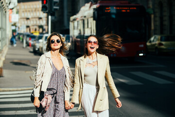 Pretty girls walking on street outdoors and having fun. Best girlfriends, urban city style. Two...