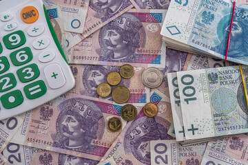  new clean smooth Polish zloty banknotes are scattered and it's time for a new calculator.