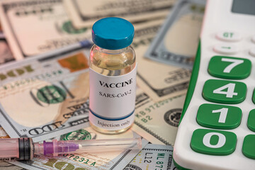 a large sum of dollars with a vaccine new calculator lie in the hospital on the table.