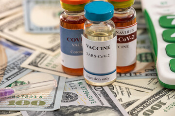 a large sum of dollars with a vaccine new calculator lie in the hospital on the table.