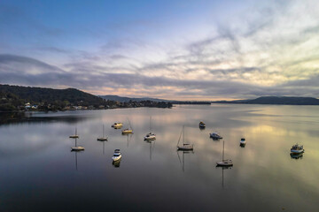 Sunrise waterscape with boats, soft clouds and reflections