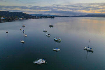 Sunrise waterscape with boats, soft clouds and reflections