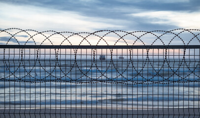Fence barbed wire and ship on the background