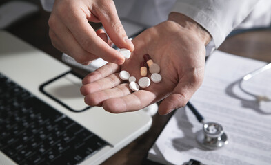 Caucasian doctor holding pills in clinic.