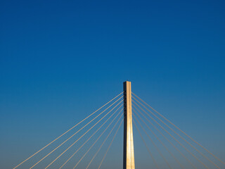 夕陽に照られた吊橋の柱とワイヤー。府中四谷橋。