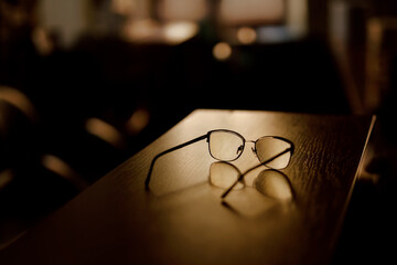 Glasses lay on the table in the evening in a patch of sunlight.