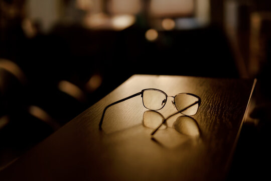 Glasses lay on the table in the evening in a patch of sunlight.