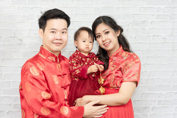Asian family, father, mother and baby in red clothes celebrating Chinese New Year
