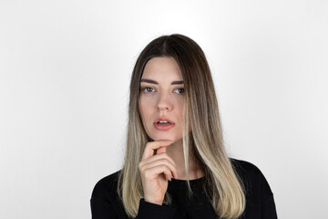 Young beautiful girl wearing casual clothes over isolated white background with hand on chin thinking about question, pensive expression. Smiling with thoughtful face. Doubt concept.
