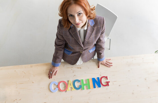 Coach looking up with alphabets arranged on desk at home