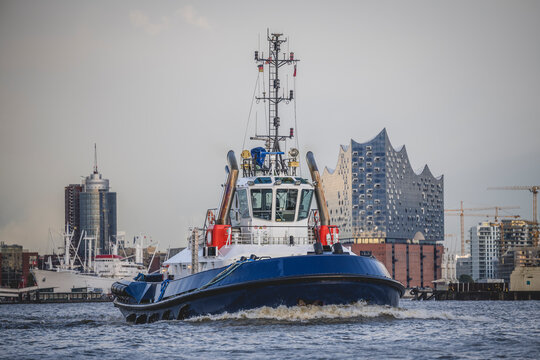 Germany, Hamburg, Tugboat on Elbe canal with Elbphilharmonie in background