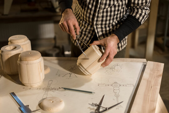 Woodworker measuring wood with equipment in workshop