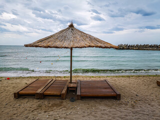 Sun umbrellas on the beach, sea water, golden sand.