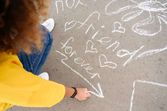 Woman drawing with chalk on street