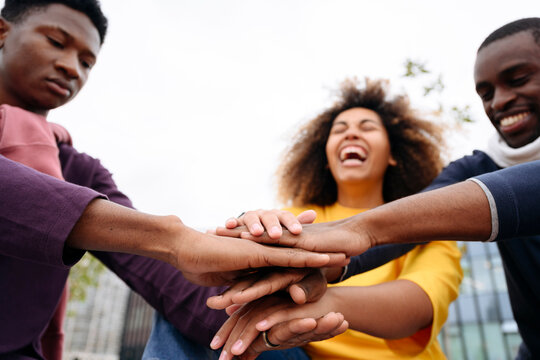 Cheerful friends doing hands stack