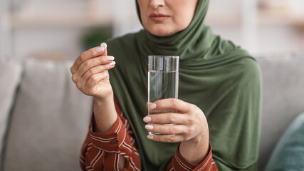 Unrecognizable Muslim Lady Taking Pills Sitting At Home, Panorama