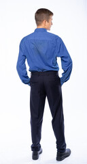 man stands with his back in the studio on a white background in trousers and a shirt