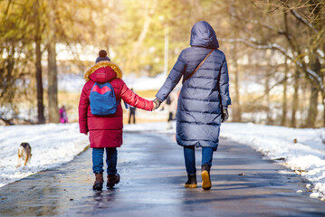 Fototapeta na wymiar A woman with her son walking in a winter Park 