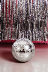Disco ball on the floor on a silver background