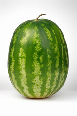 Whole of ripe watermelon on a white background, fresh fruit. Shallow depth of field	