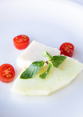Melon and feta cheese slices on a white plate. 