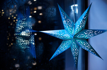 Blue Christmas decoration and frosty window with lights