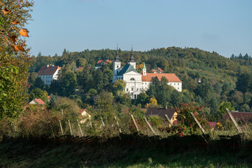 Large baroque church in the village of Vranov near Brno. Church under the hill among the woods.