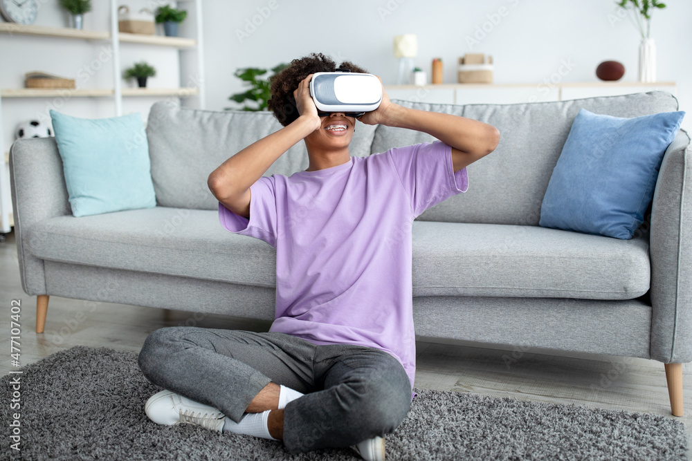 Sticker full length of black teen guy wearing vr headset and enjoying cyberspace exploration at home