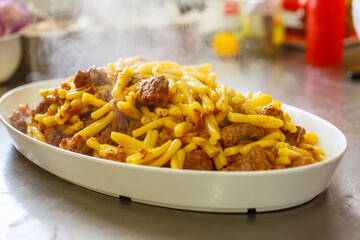 Pirofila di ceramica con pasta fumante con carne e cipolla