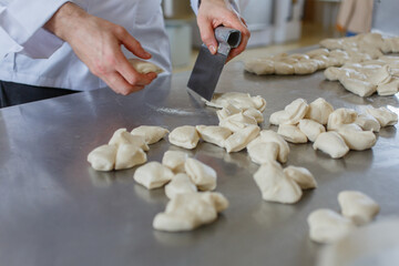 Panettiere mentre prepara i panetti di pane da infornare