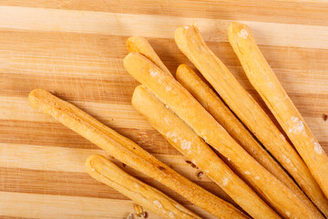 Grissini di pane fotografati su un tagliere di legno
