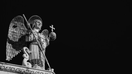 Saint Michael the Archangel defeats the Dragon, a medieval 13th century statue a the top of St...
