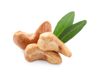 Tasty organic cashew nuts and green leaves isolated on white