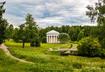 Summer landscape in the city Park with trees, pavilion, stone bridge over the river, sky with clouds