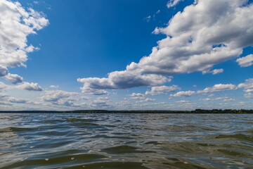 Summer landscape with river, opposite shore and sky with clouds