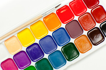 palette of watercolor paints with brush