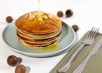 Stack of macadamia pancakes sprinkled with chopped nuts. Traditional Hawaiian dessert.