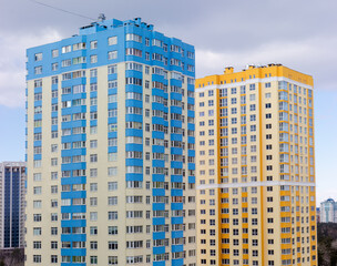 Fototapeta na wymiar Fragment of multi story apartment buildings facades against the sky