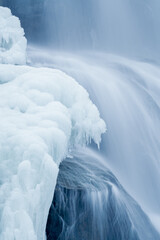 arctic landscape of frozen water from a waterfall in long exposure photography in the mountains