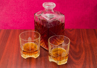 Whisky in two glasses and decanter on a wooden table