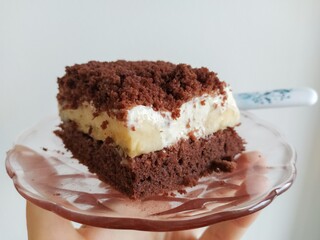 Cream piece of cake with icing and banana