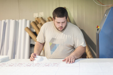 Logistic printing technician worker controls and arranges the printed material