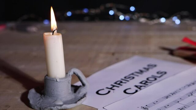 Christmas carol song sheet with candle and gift