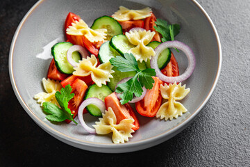 pasta salad no meat tomato, cucumber, farfalle, healthy meal diet snack on the table copy space food background rustic