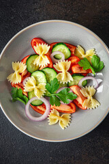 pasta salad no meat tomato, cucumber, farfalle, healthy meal diet snack on the table copy space food background rustic
