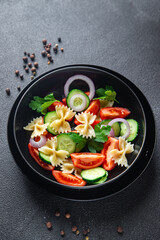 pasta salad no meat tomato, cucumber, farfalle, healthy meal diet snack on the table copy space food background rustic