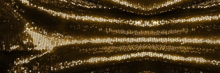 Sparkle golden fabric texture with sequins . Glitter shine background. Banner.
