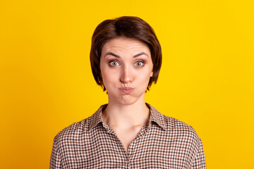 Photo of young pretty woman pouted cheeks have fun hold breath humorous isolated over yellow color...