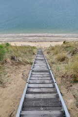 Fototapeta na wymiar Big wooden stairs in the dunes to reach the sea. Gironde France