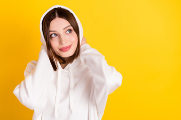Photo of pretty cozy lady look empty space touch hood wear white sweatshirt isolated yellow color...
